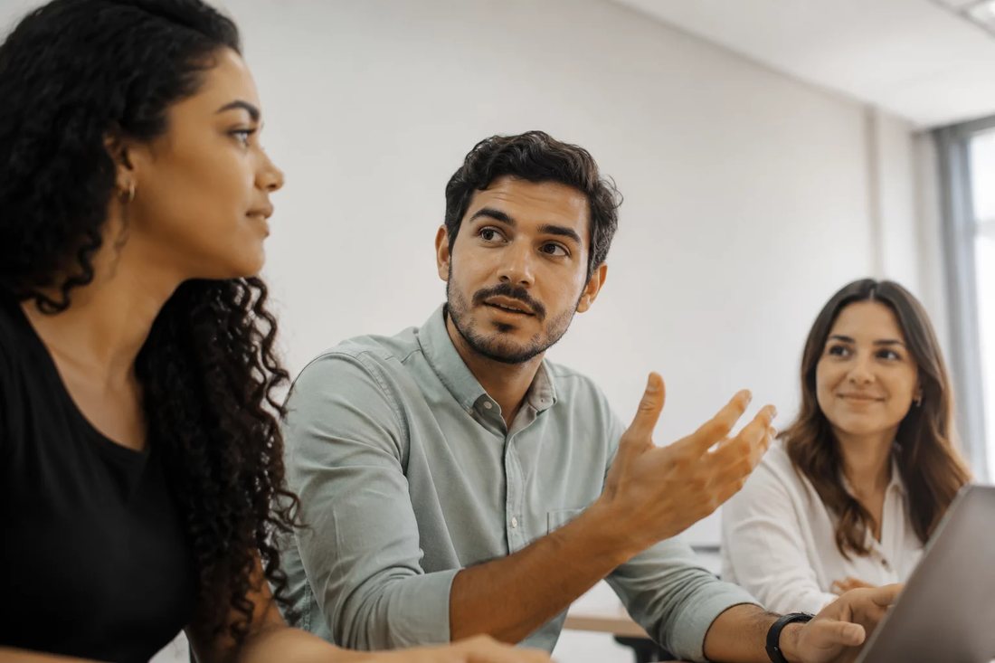 Participante falando de pé enquanto o restante da turma acompanha sentado