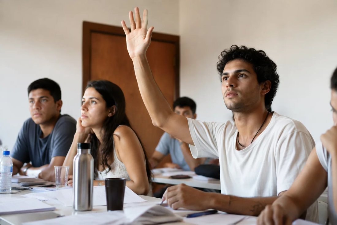 Facilitador de pé apontando para um argumento escrito no quadro durante a sessão